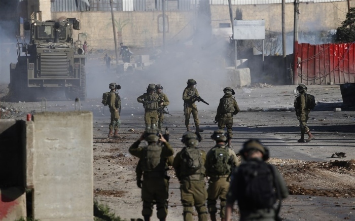 Palästinenser werfen Steine auf israelische Truppen, als es nach einem Protest gegen die Ermordung von neun Palästinensern in Dschenin im Dorf Beita nahe der Westbankstadt Nablus zu Zusammenstößen kommt. Foto: epa/Alaa Badarneh