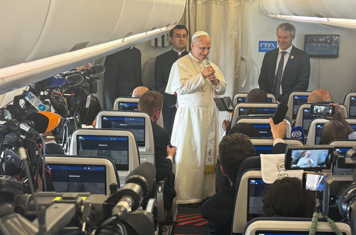 Papst Leo XIV. äußert sich während seiner Afrika-Reise im Flugzeug auf dem Weg nach Angola vor Journalisten. Foto: Christoph Sator/dpa