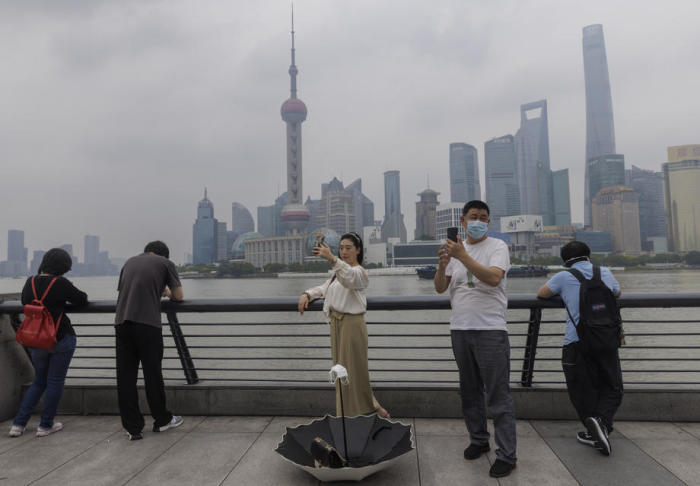 In Shanghai posieren Menschen nach der Lockerung der COVID-19-Beschränkungen für Fotos auf dem Bund. Foto: epa/Alex Plavevski