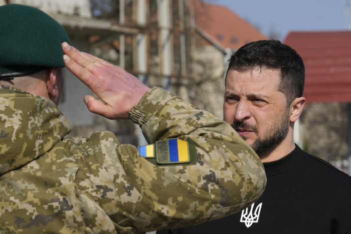 Ein Soldat salutiert vor Wolodymyr Selenskyj (r), Präsident der Ukraine, während ihm eine Medaille verliehen wird. Foto: Efrem Lukatsky/Ap