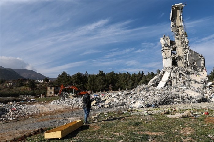 Neben einem Sarg steht ein Mann, während ein Sprengteam nach den schweren Erdbeben in Nurdagi arbeitet. Foto: epa/Sedat Suna