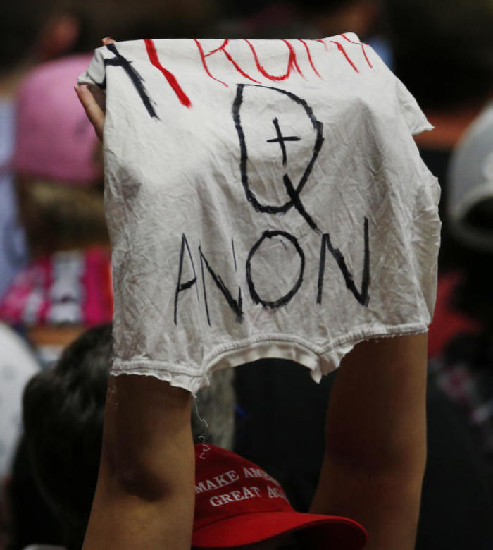 Ein Zuschauer hält ein QAnon-Banner des ehemaligen US-Präsidenten Donald Trump hoch. Foto: epa/Cj Gunther