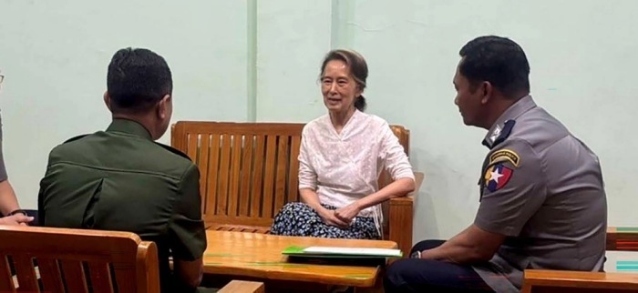 Aung San Suu Kyi sitzt mit Militär- und Polizeivertretern an einem unbekannten Ort. Ihre Haftstrafe wurde in Hausarrest umgewandelt. Foto: EPA/Myanmar Military Information Team