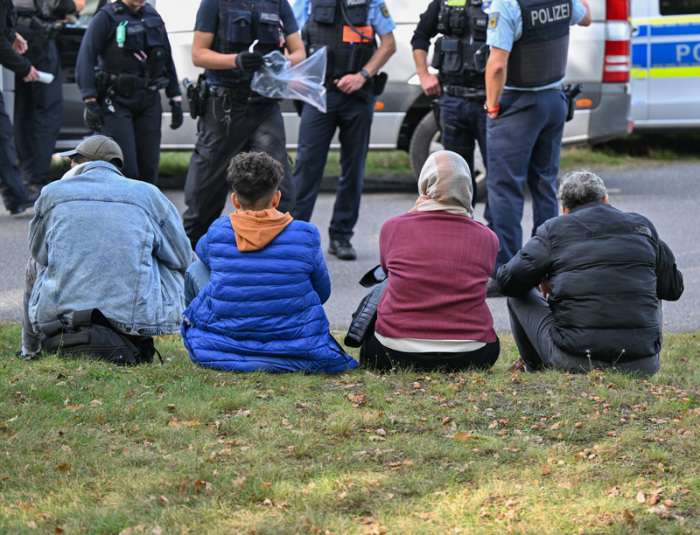Unerlaubt eingereiste Migranten werden von Beamten der Bundespolizei bei einem Aufgriff nahe der deutsch-polnischen Grenze in Forst (Lausitz) bewacht. Foto: Patrick Pleul/dpa