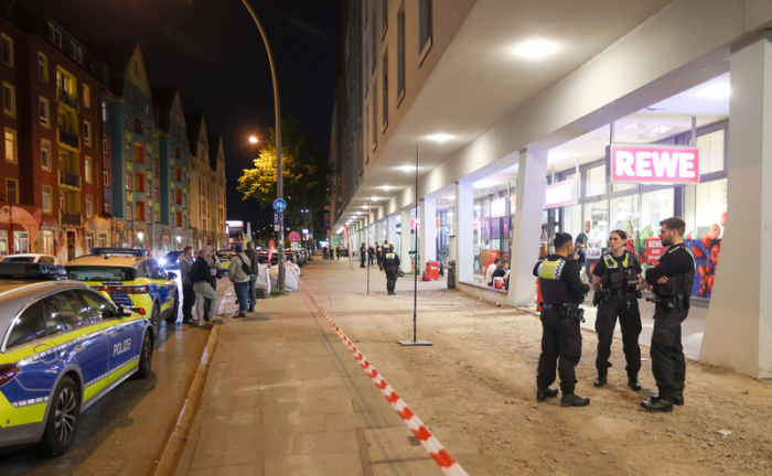 Polizisten stehen vor einem Supermarkt im Stadtteil Altona. Nach einem Streit zwischen zwei Menschen in einem Supermarkt ist eine Person mit mehreren Schnitt- und Stichverletzungen in ein Krankenhaus gebracht worden. Foto: Bodo Marks/dpa