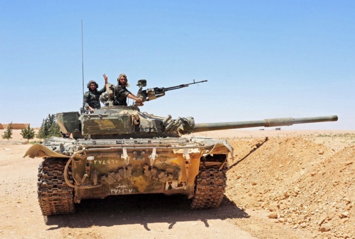 Syrische Soldaten zeigen ein V-Zeichen auf einem Panzer an der Frontlinie nahe der syrisch-irakischen Grenze in Al-Tanf. Foto: epa/Str