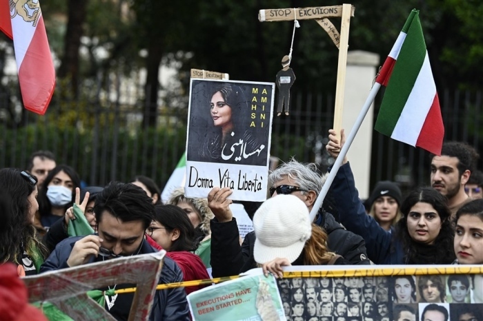 Vor der iranischen Botschaft in Rom hält eine Person ein Plakat, das die verstorbene iranische Frau Mahsa Amini mit der Botschaft 