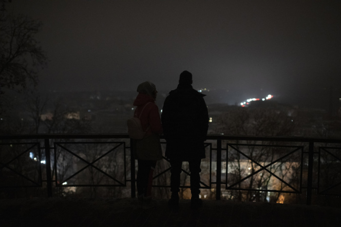 Menschen stehen während eines Stromausfalls nach einem russischen Raketenangriff an einem Aussichtspunkt. Foto: Andrew Kravchenko/Ap/dpa