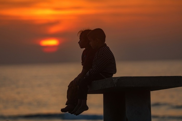 Vertriebene palästinensische Kinder sitzen am Strand im Westen von Gaza City während einer Waffenruhe im Konflikt zwischen Israel und der Hamas. Foto: EPA/Mohammed Saber