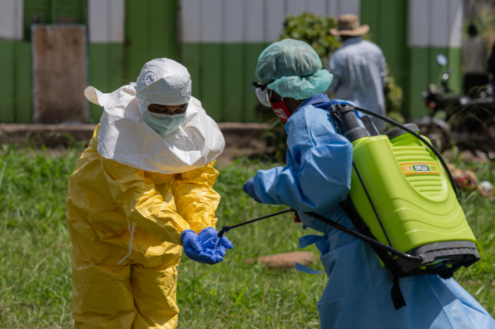 Ein Mitarbeiter des Roten Kreuzes wird nach einem Einsatz im Ebola-Gebiet in Rwampara desinfiziert. Foto: AP/Moses Sawasawa