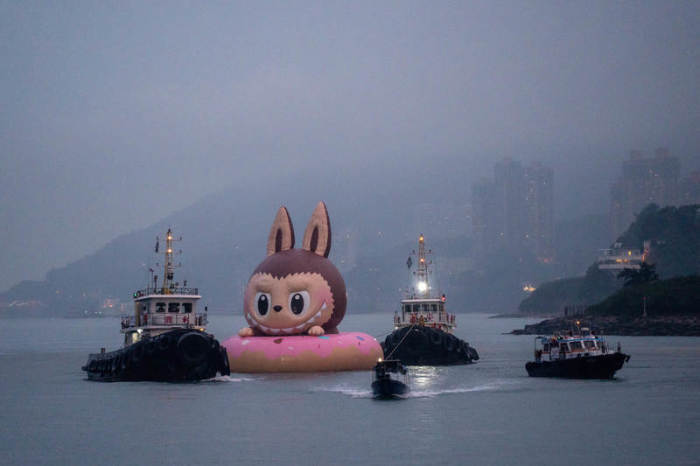 Eine große aufblasbare Labubu-Figur wird von einem Schleppboot gezogen. Foto: Vernon Yuen/Nexpher Via Zuma Press Wire/dpa