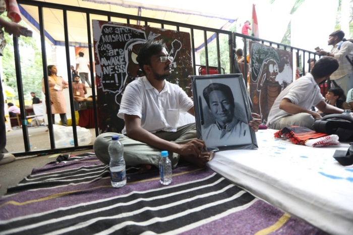 Ein Demonstrant sitzt neben einem Porträt des Klimaaktivisten Sonam Wangchuk beim unbefristeten Hungerstreik am Jantar Mantar in Neu-Delhi. Foto: epa/Vijay Pandey