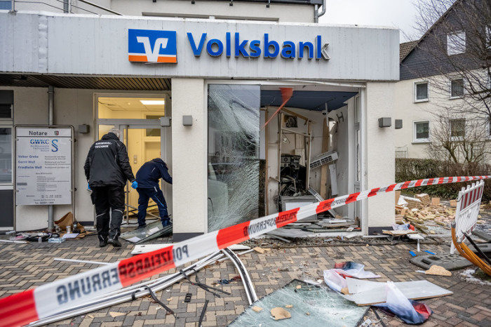 Mitarbeiter der Kriminaltechnik untersuchen eine schwer beschädigte Volksbank-Filiale. Foto: Markus Klümper/dpa