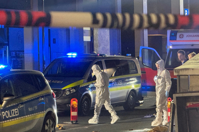 Mitarbeiter der Spurensicherung sind am Tatort in Kelkheim beschäftigt. Auf offener Straße hat ein Mann mit einer Schnittwaffe im hessischen Kelkheim seine Ehefrau getötet. Foto: Mike Seeboth/dpa