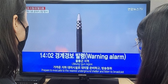Menschen verfolgen die Nachrichten über die Aufhebung der Luftangriffswarnung in einem Büro in Seoul. Foto: epa/Yonhap