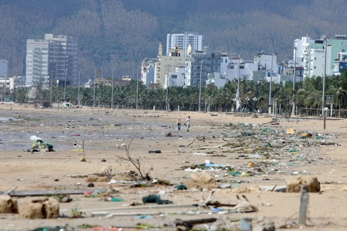 Menschen gehen am von Taifun Kalmaegi verwüsteten Strand von Quy Nhon in Zentralvietnam entlang. Foto: epa/Tien Dat