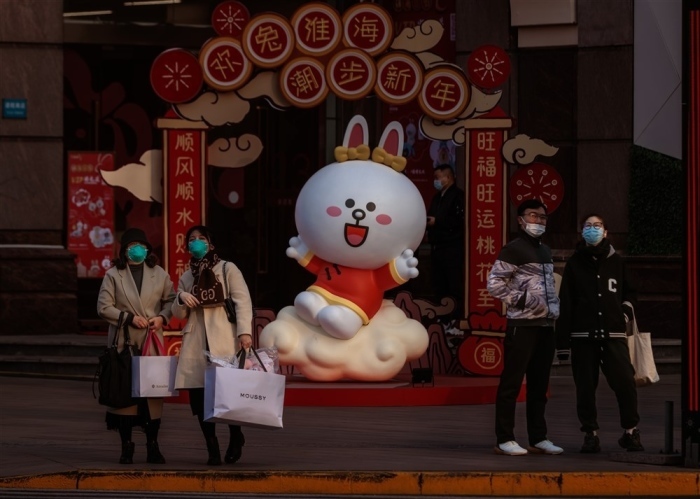 Leute stehen vor der Dekoration für das chinesische Neujahrsfest, das das Jahr des Hasen ist, in Shanghai. Foto: epa/Alex Plavevski