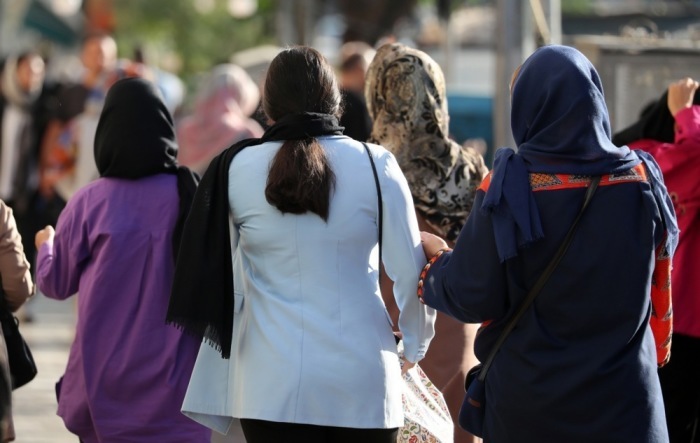 Einige iranische Frauen, die kein Kopftuch (Hijab) tragen, gehen in einer Straße in Teheran spazieren. Foto: epa/Abedin Taherkenareh