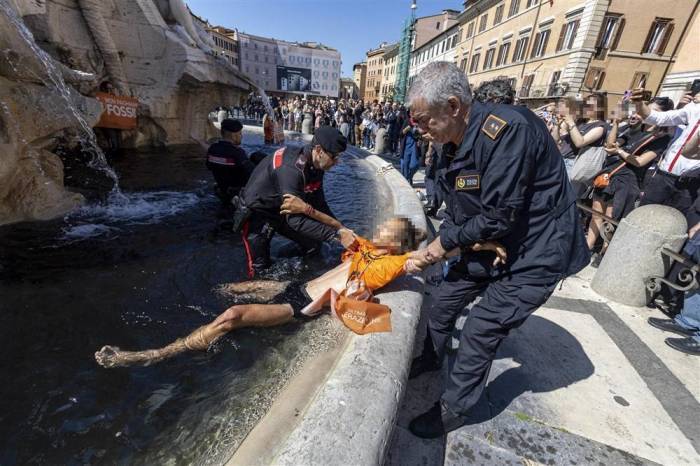 Ein Last-Generation-Aktivist wird festgenommen, nachdem er eine schwarze Flüssigkeit auf den Bernini-Brunnen auf der Piazza Navona geworfen hat. Foto: epa/Massimo Percossi