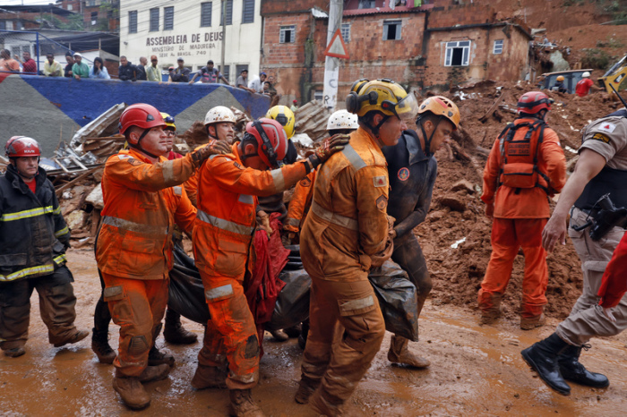 Feuerwehrleute und Helfer arbeiten nach schweren Überschwemmungen in Juiz de Fora zwischen zerstörten Häusern. Der Starkregen trifft auch Brasiliens Kaffeeanbau. Foto: Tânia Rêgo/Agencia Brazil/dpa