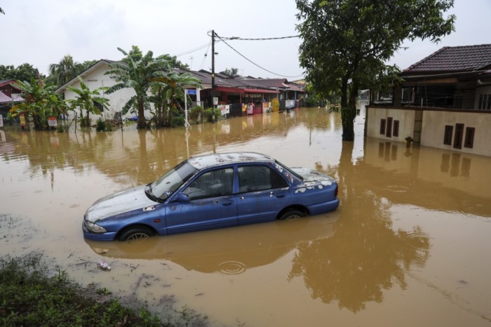 Ein Auto steckt in einer überfluteten Straße in Klang, Malaysia. Die Monsunzeit brachte ungewöhnlich heftige Regenfälle. Foto: EPA-EFE/Fazry Ismail