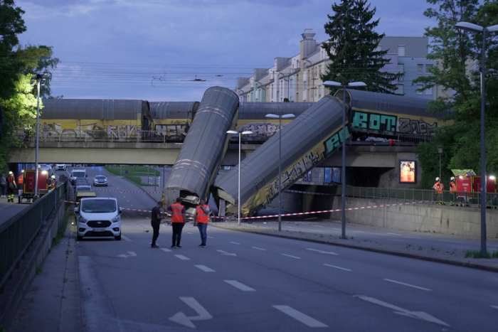 Zwei Waggons eines Güterzugs liegen auf einer Straße, nachdem sie von einer Brücke gestürzt sind. Foto: Ehsan Monajati/dpa