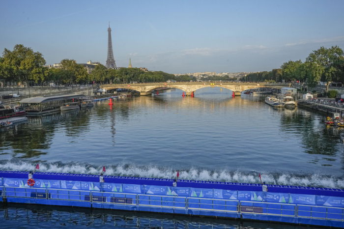 Athleten springen von der Brücke Alexander III. in die Seine, als die erste Etappe des Triathlon-Testwettbewerbs der Frauen für die Olympischen Spiele 2024 beginnt. Foto: Michel Euler/Ap/dpa