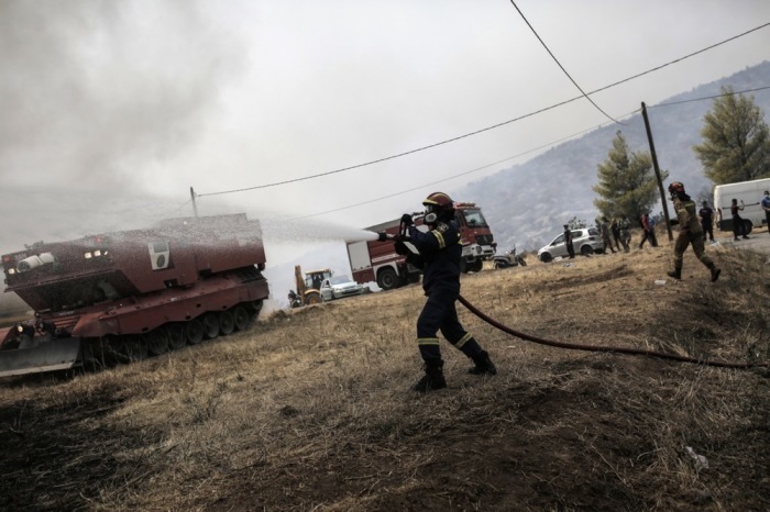 Feuerwehrleute versuchen, einen Brand in einem Wohngebiet am Fuße des Parnitha-Bergs in den Außenbezirken von Athen zu löschen. Foto: epa/Kostas Tsironis