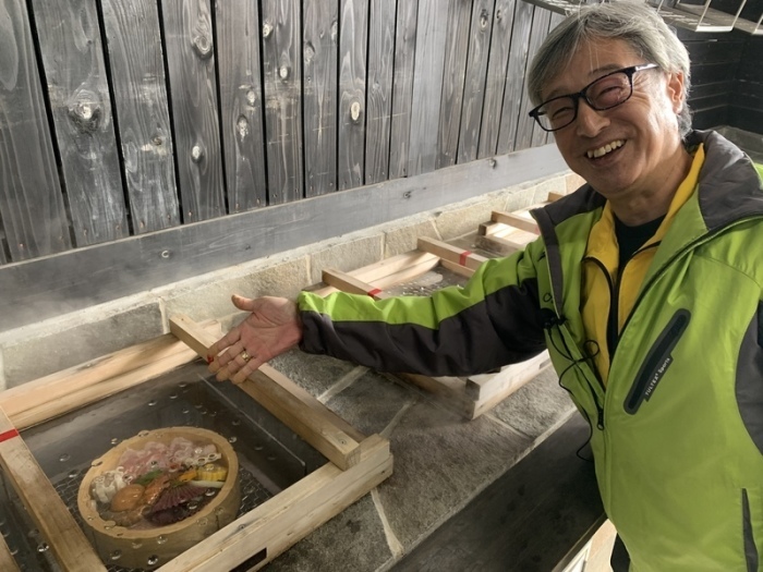 Hitoshi Tanaka, Chef des berühmten Hyotan Onsen, erklärt die traditionelle Kochmethode «Jigoku Mushi» («Höllen-Gedämpftes»). Foto: Lars Nicolaysen/dpa