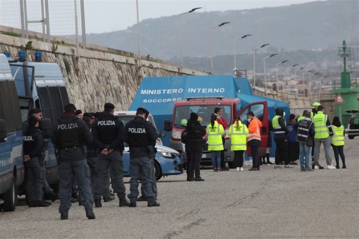 Polizeibeamte und medizinisches Personal versammeln sich, als das Patrouillenschiff Diciotti mit 584 aus dem Meer geretteten Migranten an einem Hafen in Reggio Calabria andockt. Foto: epa/Marco Costantino