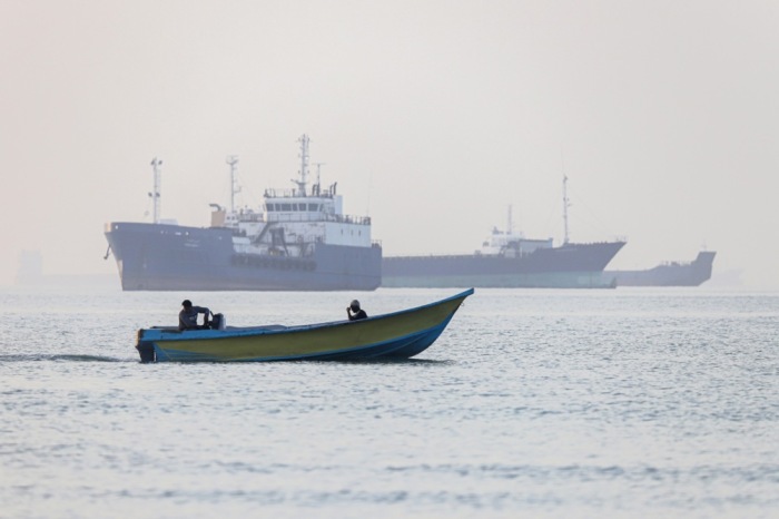 Iranische Fischer steuern ein Boot an wartenden Schiffen in der Straße von Hormus vor Bandar Abbas vorbei. Foto: epa/Amirhossein Khorgooei
