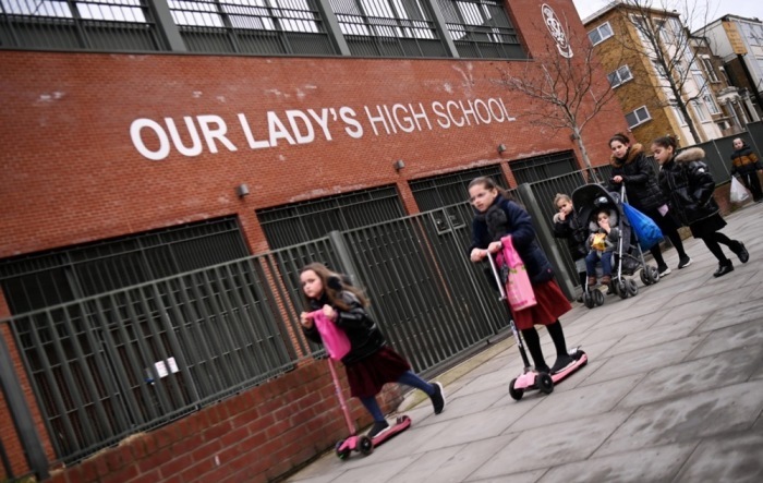 Kinder gehen an einer High School in London vorbei. Foto: epa/Andy Rain