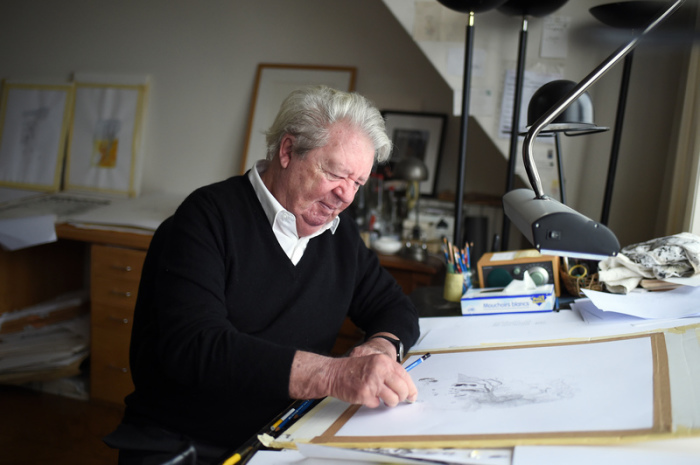 Der französische Zeichner und Karikaturist Jean-Jacques Sempe sitzt in seinem Haus in Paris an einem Tisch und zeichnet. Foto: Stephane De Sakutin