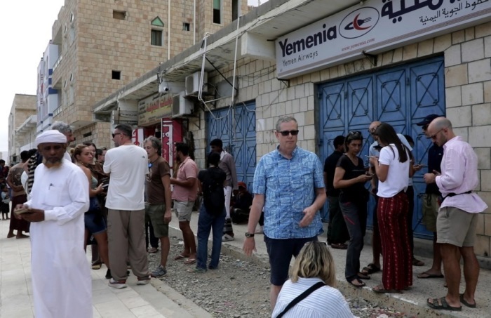Ausländische Touristen warten auf der Insel Socotra vor dem geschlossenen Büro von Yemenia Airways, nachdem der Konflikt zwischen Regierung und Southern Transitional Council Flüge lahmlegte. Foto: epa/Stringer