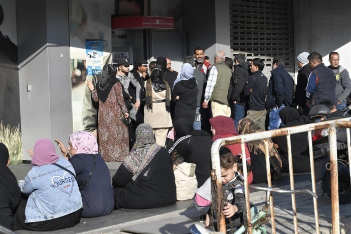 Syrische Flüchtlinge stehen vor einer Bank in Beirut Schlange, um Bargeld von einem Geldautomaten abzuheben. Foto: epa/Wael Hamzeh