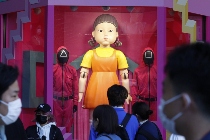 Fußgänger gehen am Shibuya-Bahnhof an einer überdimensionalen Nachbildung der «Younghee»-Puppe aus der südkoreanischen Netflix-Serie «Squid Game» vorbei. Foto: Rodrigo Reyes Marin