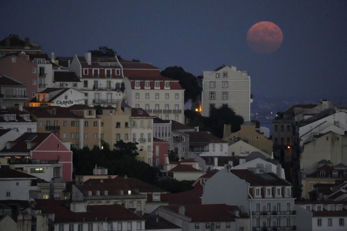 Der Vollmond geht hinter dem Stadtteil Castelo auf. (zu dpa: «Kleinkinder in Portugal mutmaßlich von Eltern ausgesetzt») Foto: Armando Franca/Ap/dpa