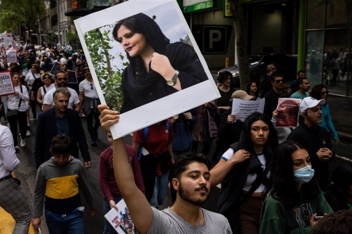 Ein Mann hält ein Bild der verstorbenen iranischen Frau Mahsa Amini während einer Solidaritätskundgebung für die Demonstranten im Iran. Foto: epa/Diego Fedele
