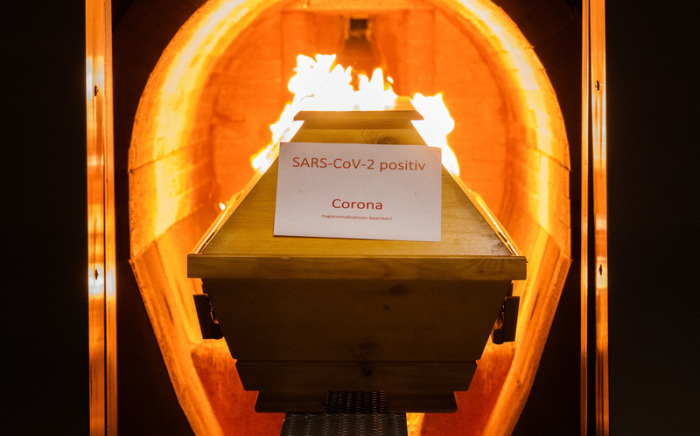 Ein Verstorbener in einem Sarg mit Aufschrift «SARS-CoV-2 positiv - Corona» wird im Krematorium «Die Feuerbestattungen Hildesheim» in einem Ofen eingeäschert. Foto: Julian Stratenschulte/dpa