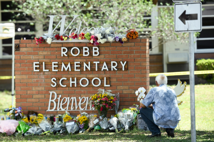 Ein Anwohner legt Blumen vor der Robb-Grundschule im Süden der Stadt ab. Ein 18 Jahre alter Amokschütze verbarrikadiert sich in Texas in einer Grundschule. Er tötet 19 Kinder und zwei Lehrer, alle in einem Klassenzimmer. Foto: Bob Daemmrich