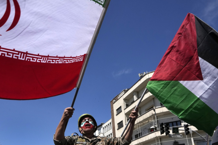 Während er die iranische Fahne bei der jährlichen Kundgebung zum Al-Quds-Tag oder Jerusalem-Tag zur Unterstützung der Palästinenser schwenkt. Foto: Vahid Salemi/Ap/dpa