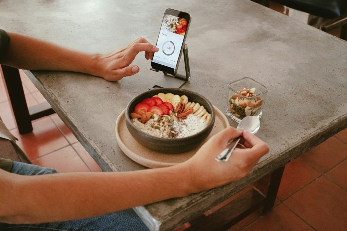 Ein Gast fotografiert im Restaurant seine Frühstücksbowl mit dem Smartphone – Benimmfragen in der modernen Gastronomie. Foto: Unsplash/Evelyn Verdin
