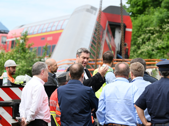 Der bayerische Ministerpräsident Markus Söder (CSU - M) besucht nach einem schweren Zugunglück den Unglücksort. Bei dem Unglück sind mindestens vier Menschen ums Leben gekommen. Foto: Angelika Warmuth/Dp