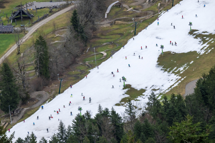 Skifahrer nutzen am Nachmittag die schmale, künstlich beschneite Fläche im Talbereich des Skigebiets Brauneck für ihr Wintervergnügen. Foto: Peter Kneffel/dpa