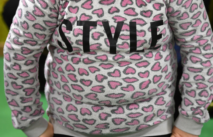 Ein übergewichtiges Kind trägt einen Pulli mit dem Schriftzug «Style». Foto: Ralf Hirschberger/dpa