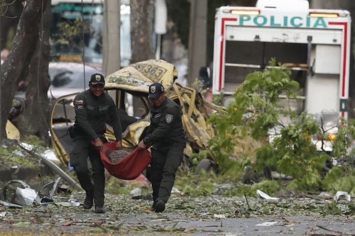 Polizisten transportieren nach einem Angriff einen Zylinder bei der Militärschule in Cali. Foto: epa/Ernesto Guzman