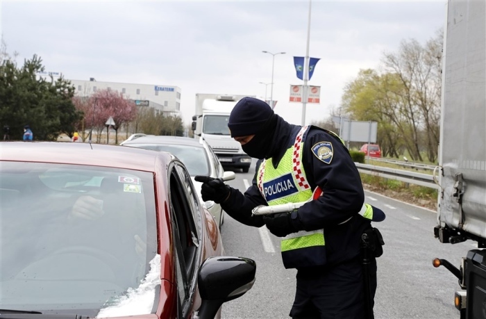 Polizisten kontrollieren Autofahrer an einem Kontrollpunkt auf einer Hauptstraße in Zagreb. Foto: epa/Antonio Bat