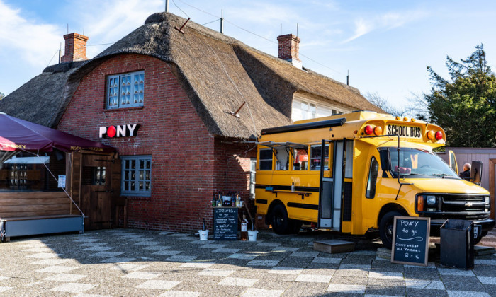 Schleswig-Holstein, Kampen (Sylt): Ein alter amerikanischer Schulbus steht als Ausschank neben der Gaststätte „Pony“ in der Straße Strönwai im Zentrum von Kampen. Foto: Axel Heimken/dpa