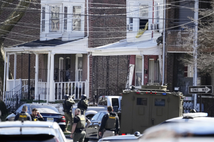 Polizisten umstellen ein Haus. Ein Verdächtiger hatte sich in dem Haus verbarrikadiert und Geiseln genommen, nachdem er in einem Vorort von Philadelphia drei Menschen erschossen hatte. Foto: Matt Rourke/Ap/dpa