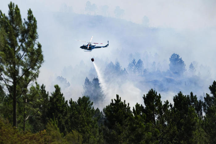 Ein Hubschrauber bekämpft einen Waldbrand im Peneda-Nationalpark, Lindoso, Viana do Castelo. Foto: epa/Armenio Belo